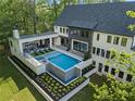 Gorgeous backyard oasis featuring a sparkling pool, spa, an outdoor kitchen and lounge area for entertaining at 4785 Merlendale Ct, Atlanta, GA 30327