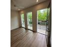Bedroom featuring hardwood floors, a ceiling fan, three large windows, and access to a balcony at 1276 Longreen Terrace Nw # 115, Atlanta, GA 30318