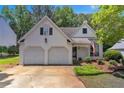 Inviting two-story home with two-car garage, traditional design, and landscaped front yard at 141 Weatherstone Dr, Woodstock, GA 30188