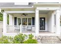 Inviting covered front porch featuring black shutters, white railing, and stylish seating area at 1486 Brooklyn Nw Ave, Atlanta, GA 30309