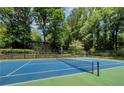 Outdoor tennis court surrounded by lush greenery, providing a private and scenic recreational area at 2610 Cumberland Ct, Smyrna, GA 30080