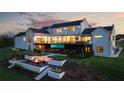 Modern farmhouse exterior with a walkout basement, a firepit, and a lush lawn at 5160 Howard Rd, Cumming, GA 30040