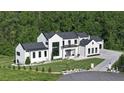 Elegant modern farmhouse featuring large windows, manicured lawn, and lush green surroundings at 5160 Howard Rd, Cumming, GA 30040