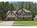 Charming two-story brick home featuring a well-manicured lawn and attached two-car garage at 1045 River Valley Dr, Dacula, GA 30019