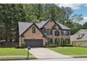 Charming two-story brick home featuring a well-manicured lawn and attached two-car garage at 1045 River Valley Dr, Dacula, GA 30019