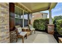 Cozy front porch with wicker seating, brick pillars and privacy landscaping at 1370 Sunnys Halo Dr, Suwanee, GA 30024