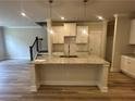 Open kitchen featuring a granite island, stainless steel sink, and ample cabinet space at 257 Depot Landing Rd # 39, Auburn, GA 30011