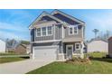 Charming two-story home with gray siding, white trim, a covered entrance, and a two-car garage at 266 Tulip Dr, Covington, GA 30016