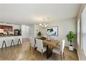 Bright dining area featuring modern chandelier and an open view of the kitchen with a breakfast bar at 7630 Volion Pkwy, Fairburn, GA 30213