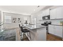 Modern kitchen with white cabinets, granite countertops, stainless steel appliances, and a stylish breakfast bar at 853 Bentley Drive Dr, Fairburn, GA 30213