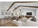 Bright open-concept living area featuring high ceilings, exposed wood beams, and modern furnishings with seamless kitchen access at 4178 Castle Pines Ct, Tucker, GA 30084