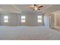 Large carpeted main bedroom features a ceiling fan, tray ceiling, and plenty of room for furniture at 612 Sidney Ct, Stockbridge, GA 30281