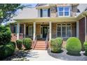 Charming front porch with stone accents, brick steps, and meticulously manicured landscaping at 737 Heritage Post Ln, Grayson, GA 30017