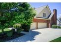 Side view of brick home showcasing a three-car garage and long driveway at 737 Heritage Post Ln, Grayson, GA 30017