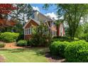 Brick two-story home with a landscaped yard and mature trees at 772 Vinings Estates Se Dr, Mableton, GA 30126