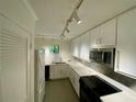 Modern kitchen featuring track lighting, white cabinets, and updated appliances at 2259 Pernoshal Ct, Dunwoody, GA 30338