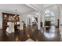 Elegant dining room featuring dark wood floors, a modern light fixture, and classic furnishings at 5860 Stoneleigh Dr, Suwanee, GA 30024