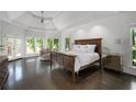 Serene main bedroom with ample natural light, a tray ceiling, and a private balcony at 5860 Stoneleigh Dr, Suwanee, GA 30024