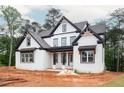 Newly constructed white brick home with black trim and covered porch on a wooded lot at 1072 Sweet Mia Ln, Powder Springs, GA 30127