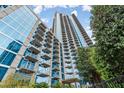 Low angle view of the modern high-rise condo building featuring multiple balconies and lush landscaping at 400 W Peachtree Nw St # 3611, Atlanta, GA 30308