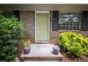 Inviting front entrance with a freshly painted green door, brick steps and potted plants at 5666 Goldfield Dr, Acworth, GA 30102