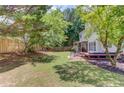 Spacious backyard featuring a wooden fence, mature trees, patio set, and outdoor seating at 1370 Stoney Field Place, Lawrenceville, GA 30043