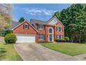 Traditional-style home boasting a lush green lawn, classic brick facade, and a two-car garage at 1370 Stoney Field Place, Lawrenceville, GA 30043