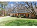 Quaint brick home featuring manicured lawn and front-facing two-car garage at 5270 Forest Brook Pkwy, Marietta, GA 30068