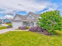 A well-maintained front lawn features a gray single-story house, manicured shrubs, and an attached garage at 101 Wins Walk, Cartersville, GA 30121