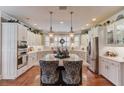 Bright kitchen with stainless steel appliances, white cabinets and an island with pendant lighting at 1292 Green Turf Dr, Snellville, GA 30078