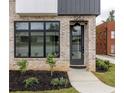 Contemporary home entrance with black door, transom windows, modern lighting, and professionally landscaped yard at 1962 8Th St, Chamblee, GA 30341