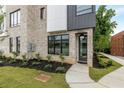 Modern home's entry with a black door, manicured landscaping, and gray brick exterior at 1962 8Th St, Chamblee, GA 30341