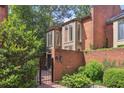 Brick exterior showcases a private entrance with an iron gate, surrounded by greenery at 49 Willow Gln, Atlanta, GA 30342