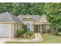 Inviting home exterior showcasing a well-kept lawn, mature shrubs, and stone accents at 1335 Vine Cir, Mcdonough, GA 30253