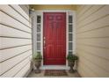 Welcoming entryway featuring a red front door, decorative wreath, sidelights, and potted plants, creating a warm entrance at 3001 Garland Sw Dr, Marietta, GA 30008