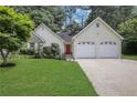 Inviting home showcasing a well-maintained lawn, brick accents, a red front door, and a two-car garage at 3001 Garland Sw Dr, Marietta, GA 30008
