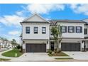 Exterior view of a townhome with a two-car garage and manicured landscaping at 711 Dodd N Ln # 166, Buford, GA 30518