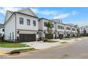 Street view of townhomes with two-car garages and nicely maintained landscaping at 711 Dodd N Ln # 166, Buford, GA 30518