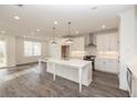 Open-concept kitchen with stainless steel appliances, a large island, and modern lighting offers ample space at 711 Dodd N Ln # 166, Buford, GA 30518