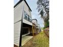 A view of the back of the house with a wooden deck, a concrete patio, and a manicured lawn at 1320 Stanley Park Dr # 141, Decatur, GA 30033
