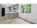 Modern kitchen with gray cabinets, sleek countertops, a breakfast bar and stainless steel appliances at 4205 Mabry Ne Rd, Roswell, GA 30075