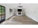 Spacious living room featuring a cozy fireplace, modern ceiling fan, and stylish wood floors at 4205 Mabry Ne Rd, Roswell, GA 30075