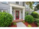 Close up of the front door, with lush landscaping, mulched beds, and a brick walkway at 4957 Day Lily Nw Way, Acworth, GA 30102