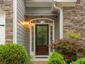 Close-up of the home's front door with stone accents, tasteful landscaping, and exterior lighting at 613 Wiley Ct, Canton, GA 30115