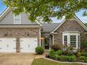 Charming home featuring a stone facade, well-manicured landscaping, and a two-car garage at 613 Wiley Ct, Canton, GA 30115