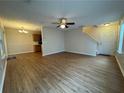 Open-concept living area with modern ceiling fan, hardwood floors, and staircase at 143 Ilex Dr, Canton, GA 30114