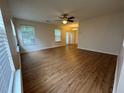 Spacious living room featuring hardwood floors, a ceiling fan, and ample natural light from the windows at 143 Ilex Dr, Canton, GA 30114