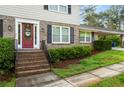 Inviting front entrance with a vibrant red door, brick steps, and manicured landscaping at 4379 Bonaparte Dr, Tucker, GA 30084