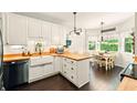 Well-lit kitchen featuring white cabinets, butcher block countertops, a farmhouse sink, and stainless steel appliances at 827 Pinehurst Dr, Woodstock, GA 30188