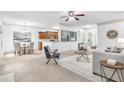 Open-concept living room featuring neutral tones, a ceiling fan, and seamless flow into the kitchen and dining area at 891 Channel Dr, Lawrenceville, GA 30046